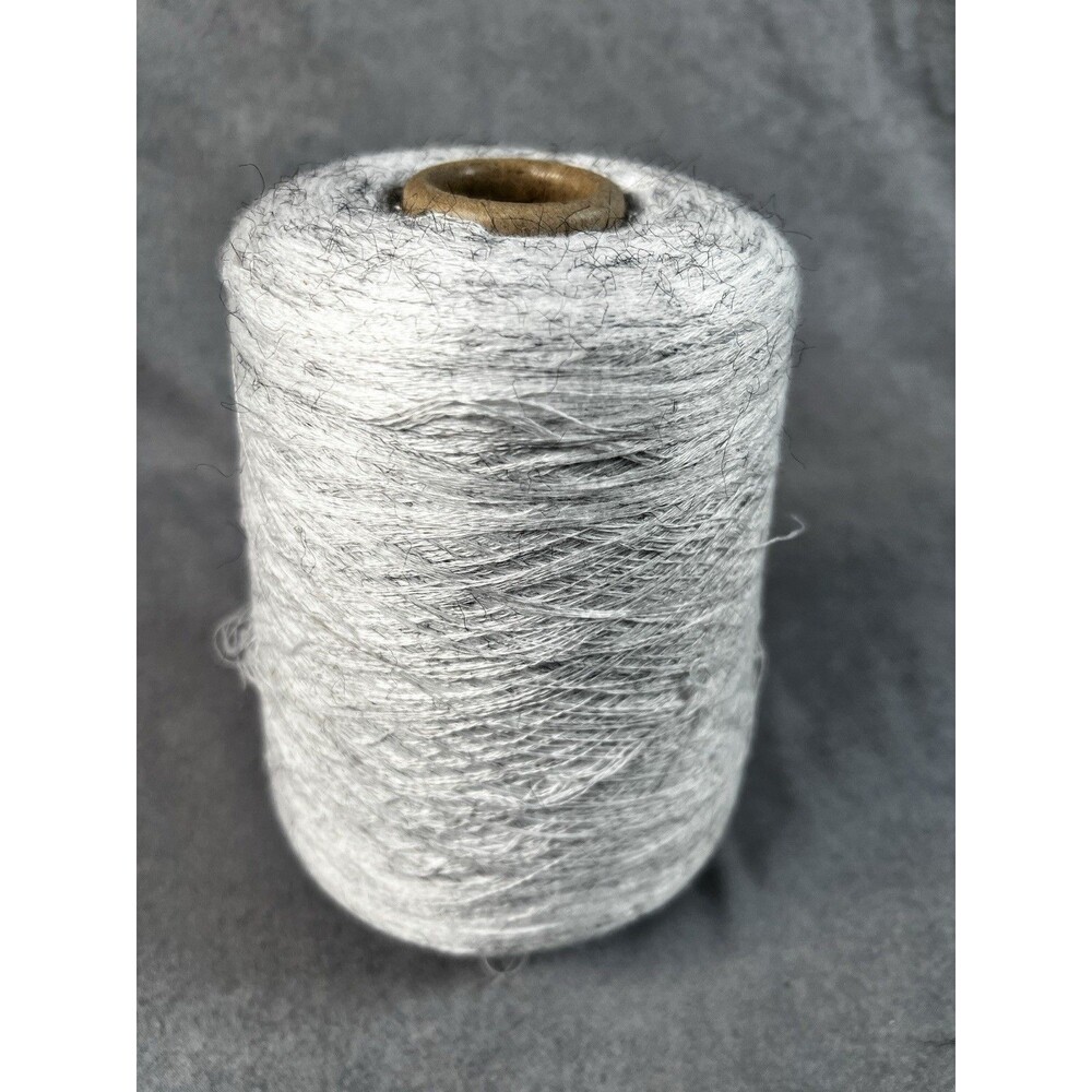 Cone of heathered gray melange yarn weighing 555g￼